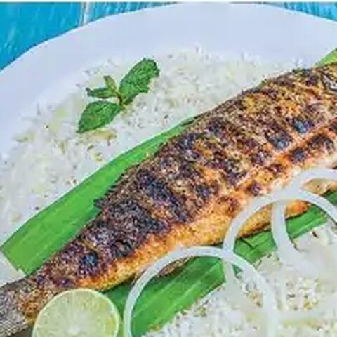 وجبة سمكة مشوية مع السلطة والصلصة والسمن المحلي